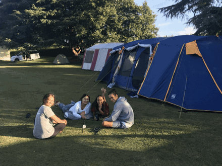 Children sitting on grass next to tent