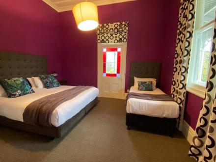 Villa bedroom with a single and double bed with red walls