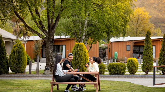 Group of friends on a picnic table in a holiday park
