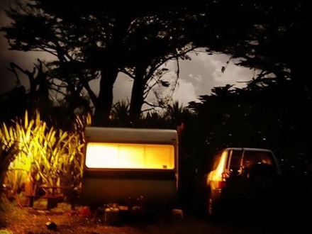 Cute retro caravan, lights blazing at Sunrise