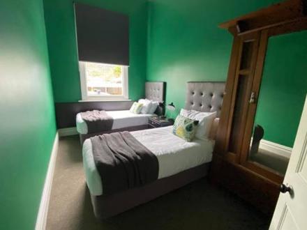 Bright green bedroom with a double and single bed