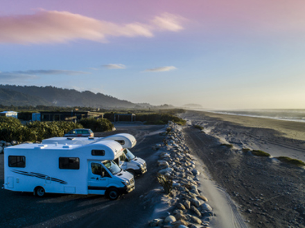 2 large white motorhomes parked by the sea wall in our Beachfront unpowered sites