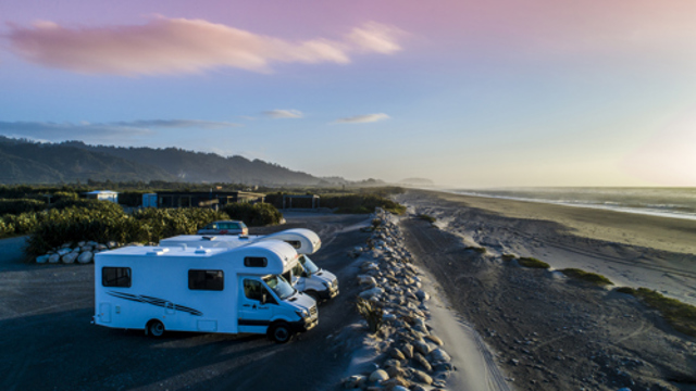 2 large white motorhomes parked by the sea wall in our Beachfront unpowered sites